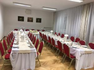 a conference room with long tables and red chairs at U Ferka in Lemešany