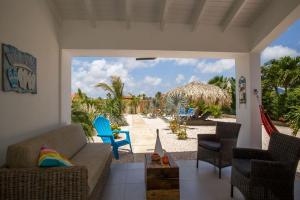 a living room with a couch and chairs on a beach at Appartement Barracuda in Kralendijk