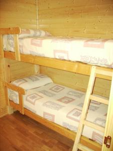 two bunk beds in a room with wooden walls at Camping Cañones de Guara y Formiga in Panzano