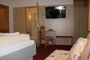 クリンゲンタールにあるLandhotel Gasthof Zwotaのベッドと壁にテレビが備わるホテルルームです。
