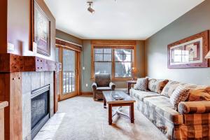 a living room with a couch and a fireplace at River Run Village in Keystone