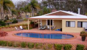 a house with a swimming pool in front of a house at Copper Country Motor Inn in Nanango