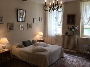 a bedroom with a bed with two lamps and two windows at AU TEMPS JADIS in Fumay