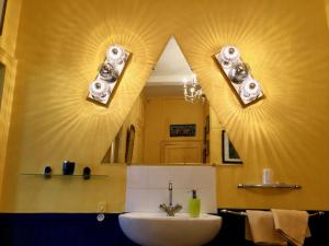 uma casa de banho com um lavatório e um espelho em AU TEMPS JADIS em Fumay