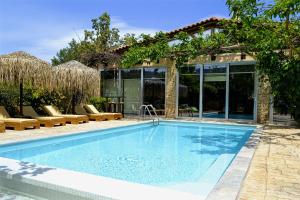 a swimming pool in front of a house at Turdus Merula Retreat in Nea Makri