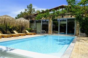 a swimming pool in front of a house at Turdus Merula Retreat in Nea Makri