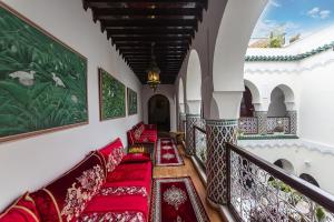 a hallway with red cushioned chairs in a building at Riad Maison Belbaraka in Marrakesh