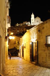 une personne marchant dans une ruelle la nuit dans l'établissement Casa Linda, à Matera
