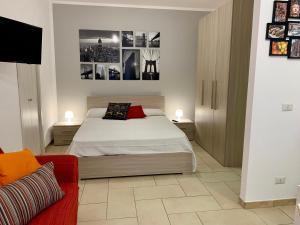 マッゼオにあるLargo Cannizzaro Apartmentsのベッドルーム1室(ベッド1台、赤いソファ付)