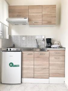 a kitchen with a white refrigerator and wooden cabinets at Rodia Apartments in Afantou