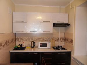 a kitchen with white cabinets and a microwave at Карасай Батыра 108 in Almaty