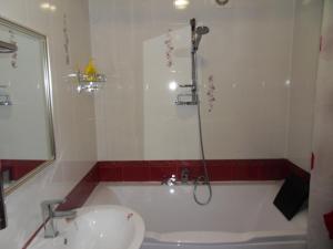 a bathroom with a bath tub and a sink at Карасай Батыра 108 in Almaty