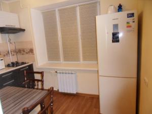 a kitchen with a white refrigerator and a table at Карасай Батыра 108 in Almaty