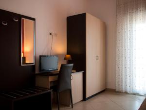 a room with a desk with a computer and a television at Il Vascello in Porto Cesareo