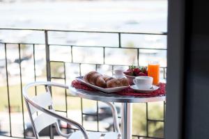 a table with a plate of pastries and a cup of orange juice at Il Vascello in Porto Cesareo