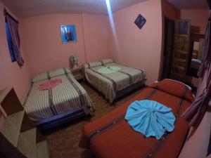 a small room with two beds and a room with two at Hotel Encuentro del Viajero in Panajachel