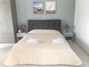 a bedroom with a large bed with two towels on it at Rodia Apartments in Afantou