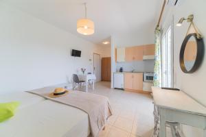 a bedroom with a bed and a table and a kitchen at Kassiani Studios in Plakias