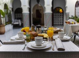 a table with plates of food and glasses of orange juice at Riad Maison Belbaraka in Marrakesh