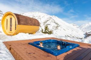 2 persone che nuotano in una vasca idromassaggio nella neve di Pianeta Oro Apartments a Livigno