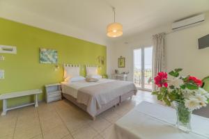 a bedroom with a bed and a green wall at Kassiani Studios in Plakias