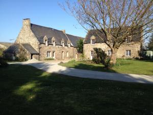 a large stone house with a tree in front of it at Maison d'hôtes "Bienlivien" in Saint-Coulomb