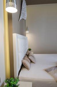 a white bed with pillows on it in a room at Aparthotel Pagidas in Hanioti