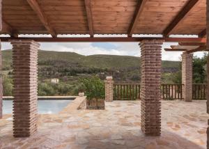 a patio with a swimming pool and a wooden roof at Villa Margarita in Anafonítria