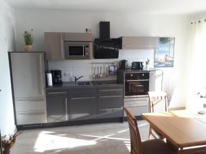 a kitchen with stainless steel appliances and a table at Haus Fernblick in Breitungen