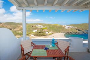 einen Tisch auf einem Balkon mit Blick auf den Strand in der Unterkunft Superior Beachfront Apartment 1 with view to the Aegean Sea in Panormos, Mykonos