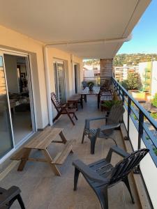 a balcony with chairs and tables on a building at Appartement 4 chambres LE BAIA in Sainte-Maxime