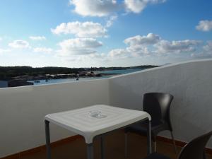 a table and chairs on a balcony with a view of the water at Hotel Roca Bella in Es Pujols