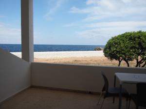 a view of the beach from a room with a table and chairs at Hotel Roca Bella in Es Pujols