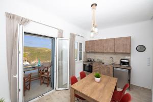 eine Küche und ein Esszimmer mit einem Tisch und Stühlen in der Unterkunft Superior Beachfront Apartment 1 with view to the Aegean Sea in Panormos, Mykonos
