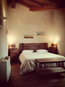 Casa della Fornace في San Vito al Torre: غرفة نوم بسرير وطاولة ومصباحين