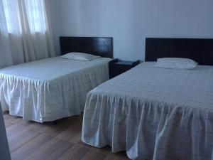 dos camas sentadas una al lado de la otra en un dormitorio en Hotel Casa don Pedro, en San Pedro La Laguna