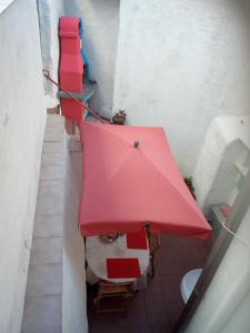 a room with a red table and a red umbrella at AL MARE, AL SOLE, SI', ma nella CASA DEL MINATORE in Buggerru