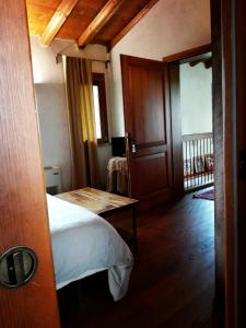 a bedroom with a bed and a table and a door at Casa della Fornace in San Vito al Torre