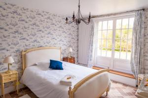 Chambre chez l'habitant في أورس: غرفة نوم مع سرير وورق جدران زرقاء