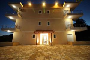 a large white building with aventh floor at night at Hotel Afrodite in Dhërmi