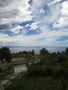 a view of the ocean from a field with a cloudy sky at Hotel Afrodite in Dhërmi