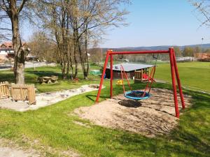 einen Spielplatz mit Schaukel in einem Park in der Unterkunft Ferienhaus am Eisgraben in Hausen