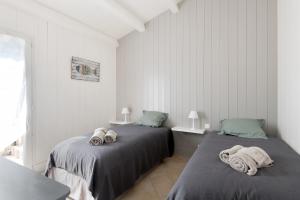 ル・ボワ・プラージュ・アン・レにあるTrès belle villa avec piscine (4*)のタオルが敷かれた白い部屋にベッドが2つある +16枚の写真