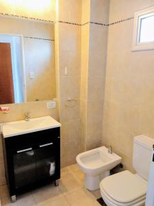 Un baño con un inodoro blanco y un lavabo. en Abasto Gardel Tango, en Buenos Aires 25 fotos más