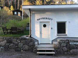 a white building with a door and a sign on it at Duvberget in Kolmården