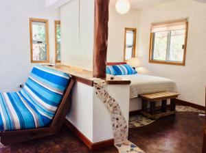 a room with a bed and a chair in it at Bungalow Bé La Kin in Cozumel