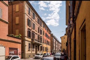 uma rua da cidade com carros estacionados e edifícios em Il Cuore di Bologna em Bolonha