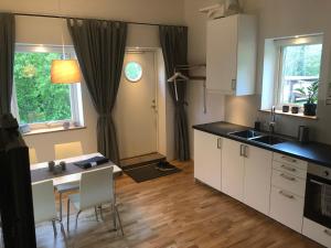 a kitchen with white cabinets and a table and chairs at Duvberget in Kolmården +5 photos