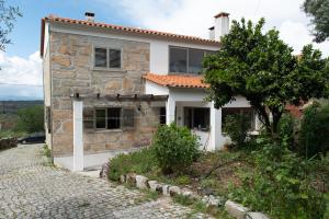 a stone house with a pathway in front of it at Casa dos Cabecinhos in Oliveira do Hospital