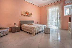 a bedroom with pink walls and a bed and a window at Il Nespolo in Vico Equense